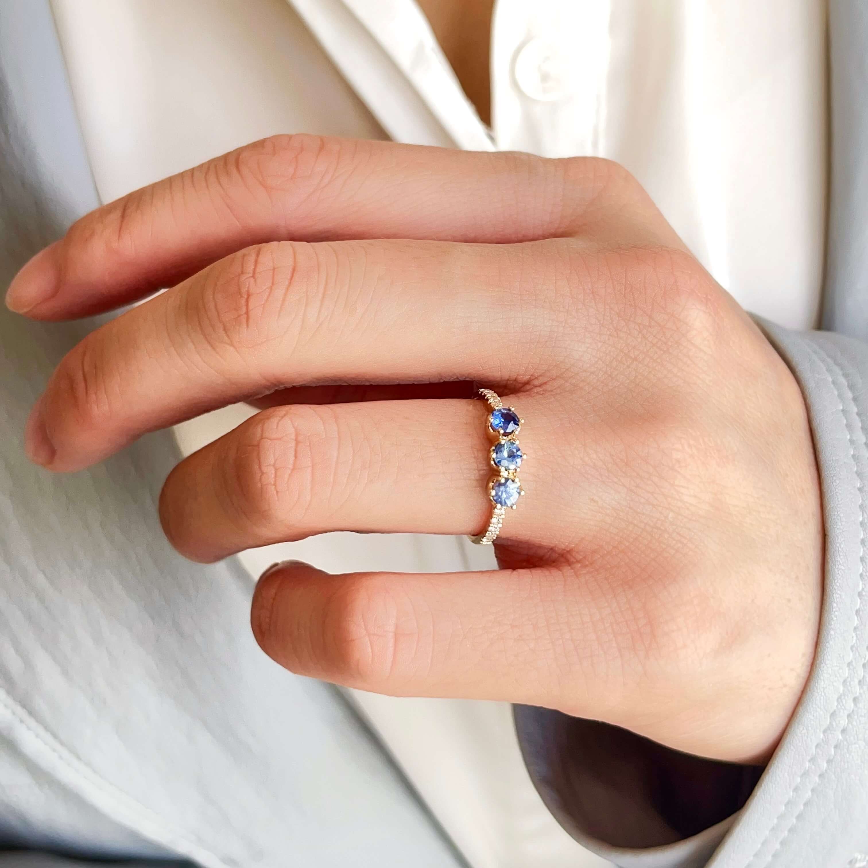 model wearing a 14ct solid gold trio blue sapphire ring