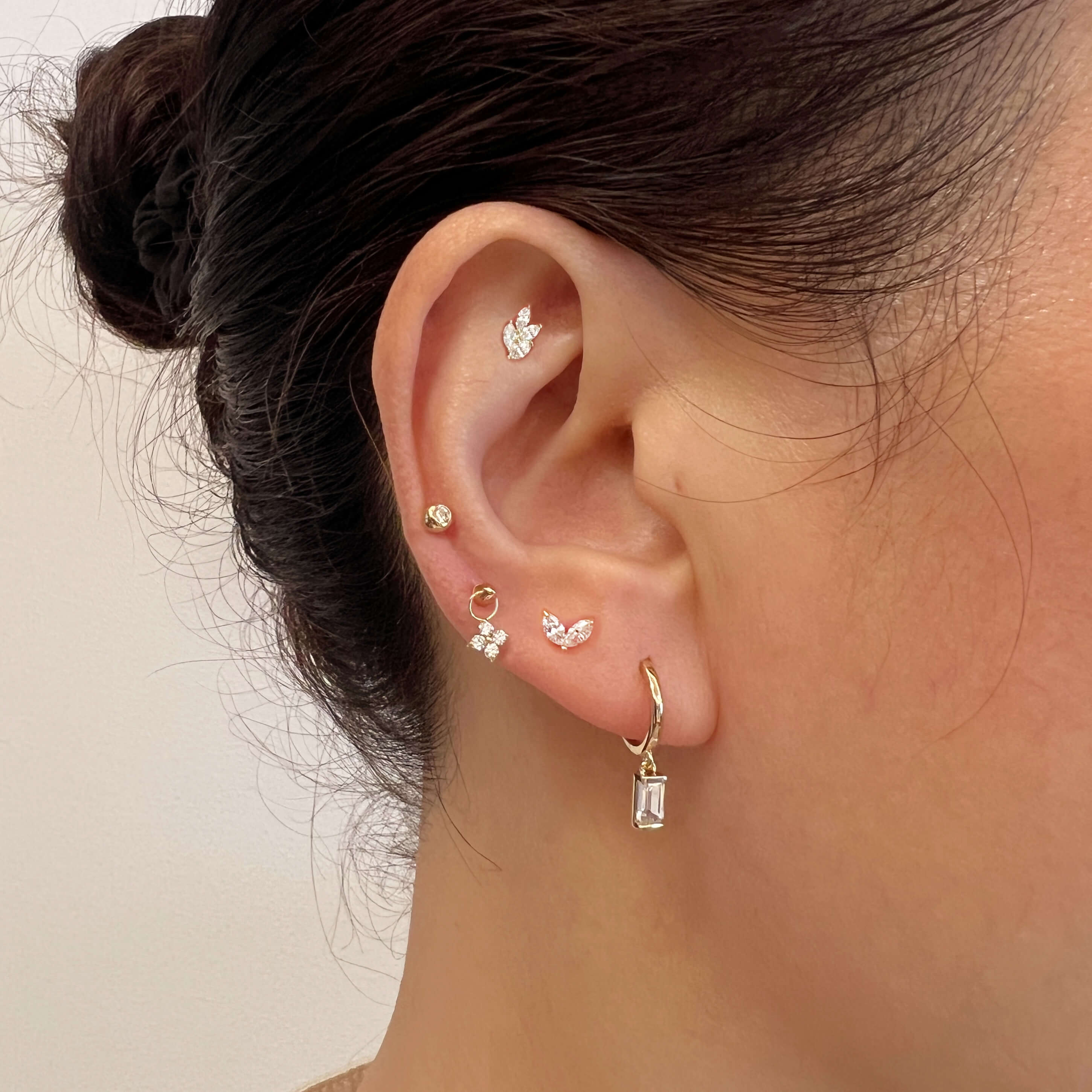 model wearing a curated ear stack with multiple flat back earring studs